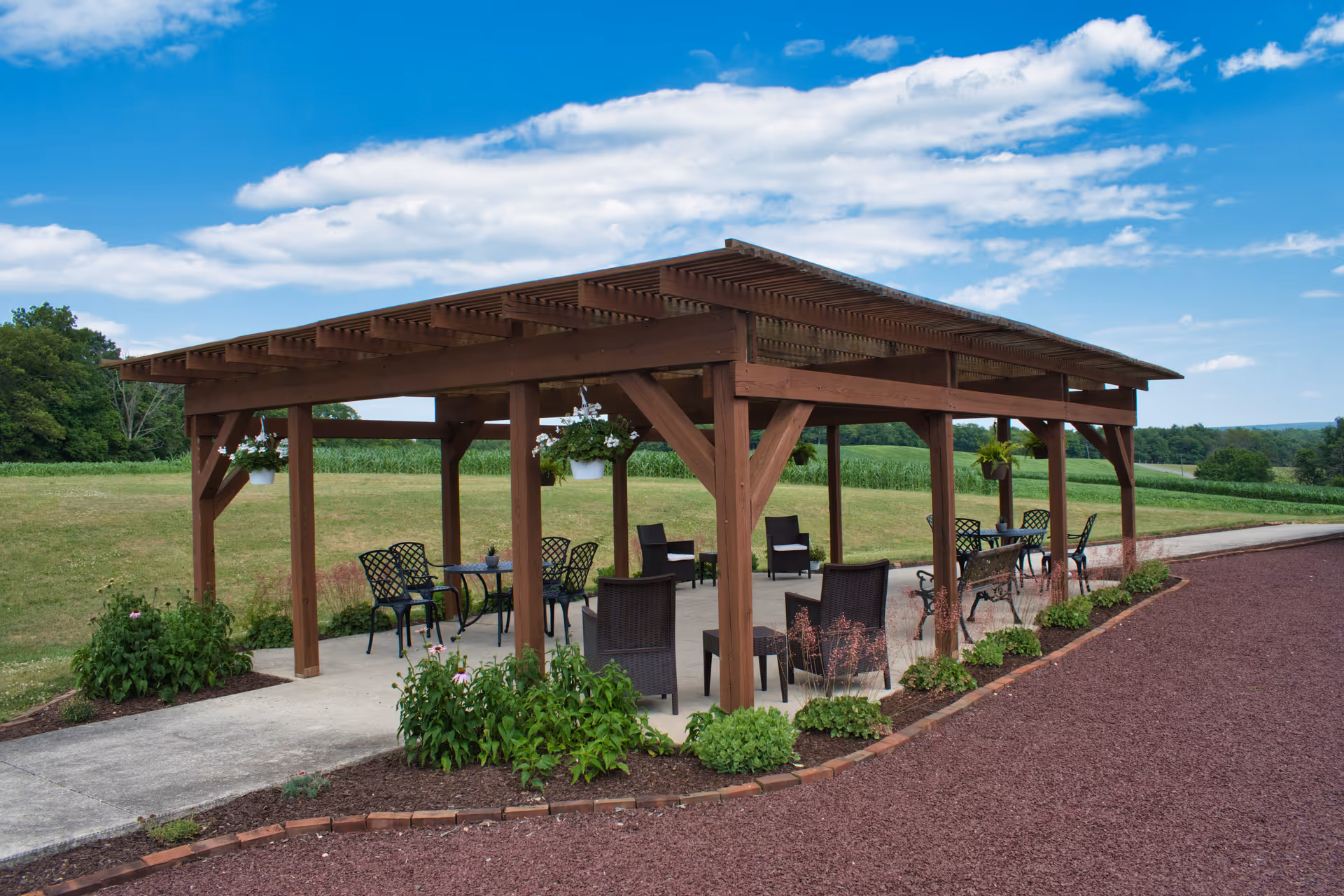 Wooden pergola with outdoor seating on a paved patio.