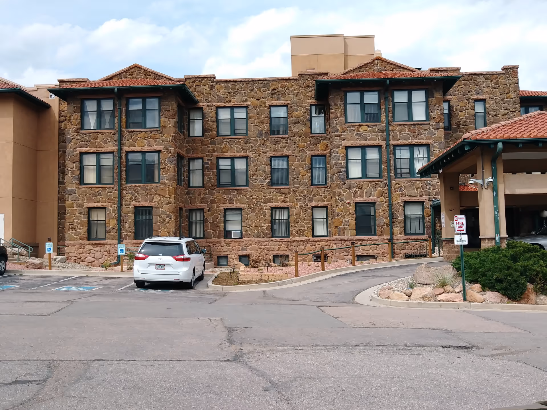 Exterior view of Mount St Francis Nursing Center building with stone facade and parking lot.