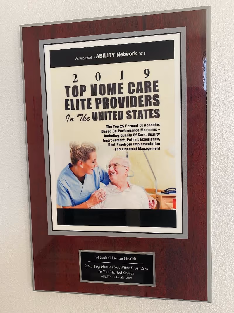 Framed award plaque displaying a nurse with an elderly patient photo at St Isabel Home Health.