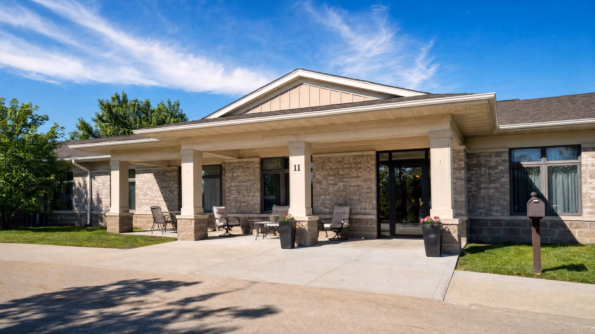 Mulberry Place front entrance with stone columns and outdoor seating.