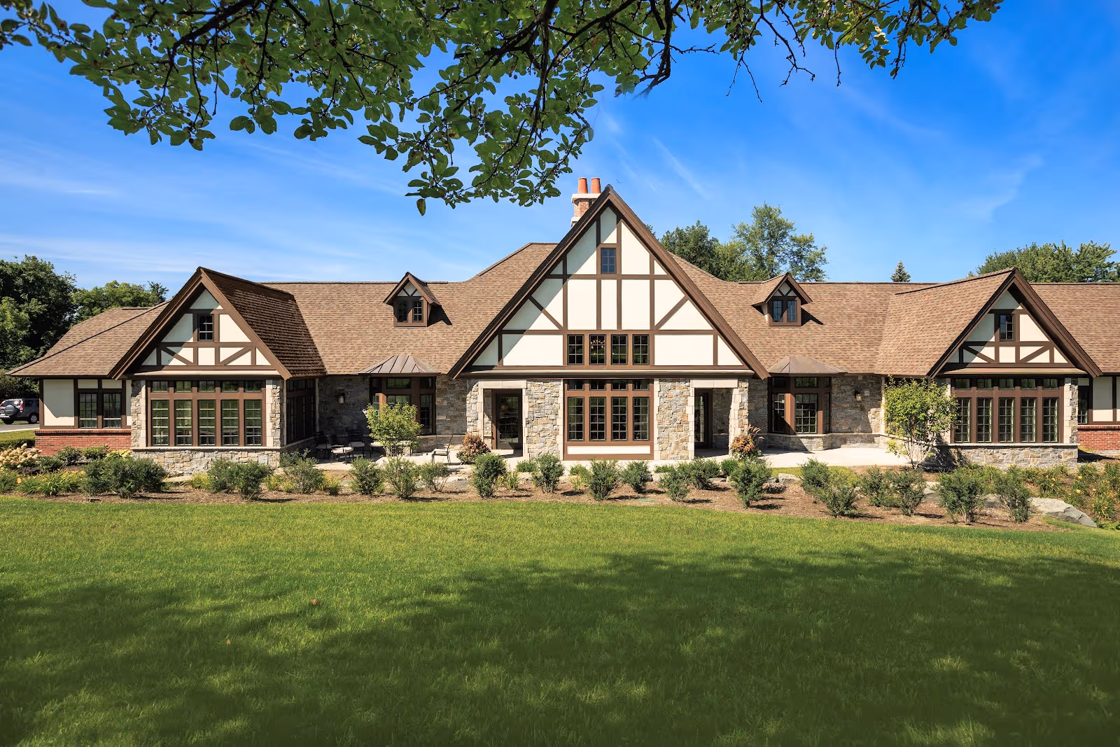 Front exterior view of Loudonville Assisted Living Residence, Tudor-style with a green lawn.