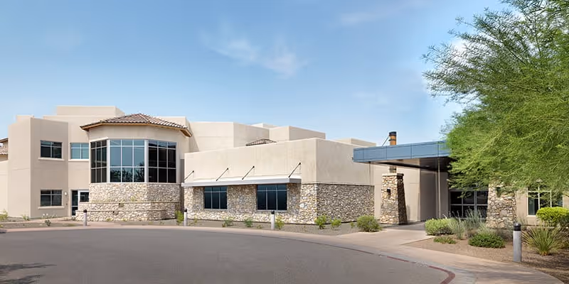 Exterior view of Sagewood Desert Willow AL and MC facility with stone accents and desert landscaping.