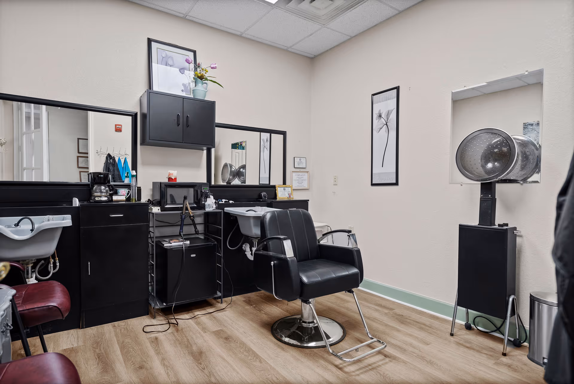 Hair salon in a senior living facility with mirrors, sinks, and styling chairs.