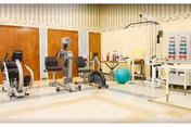 Bright indoor fitness area in a senior living facility with exercise machines.