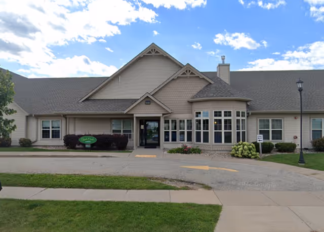Exterior view of Apple Creek Place senior living facility with entrance and landscaping.