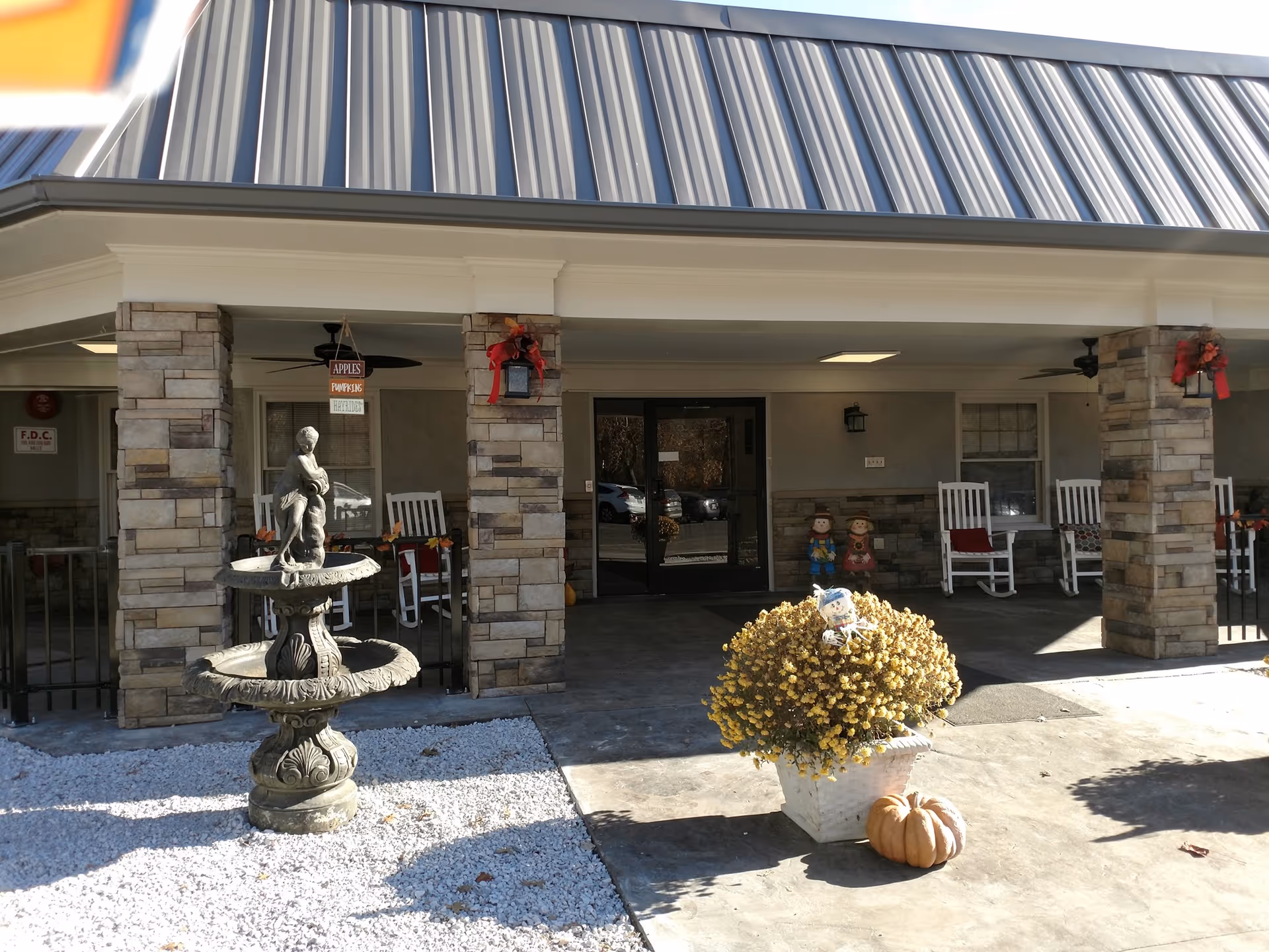 Front entrance of Camden Healthcare & Rehab Center with stone pillars and pumpkins