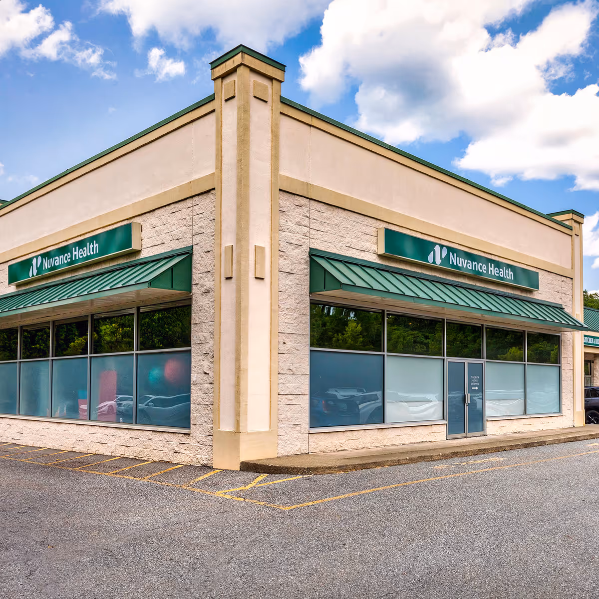 Exterior view of a Nuvance Health building with large glass windows and green signage.