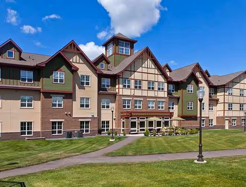 Front exterior of The Homestead at Anoka, a multi-story senior living building with lawn.