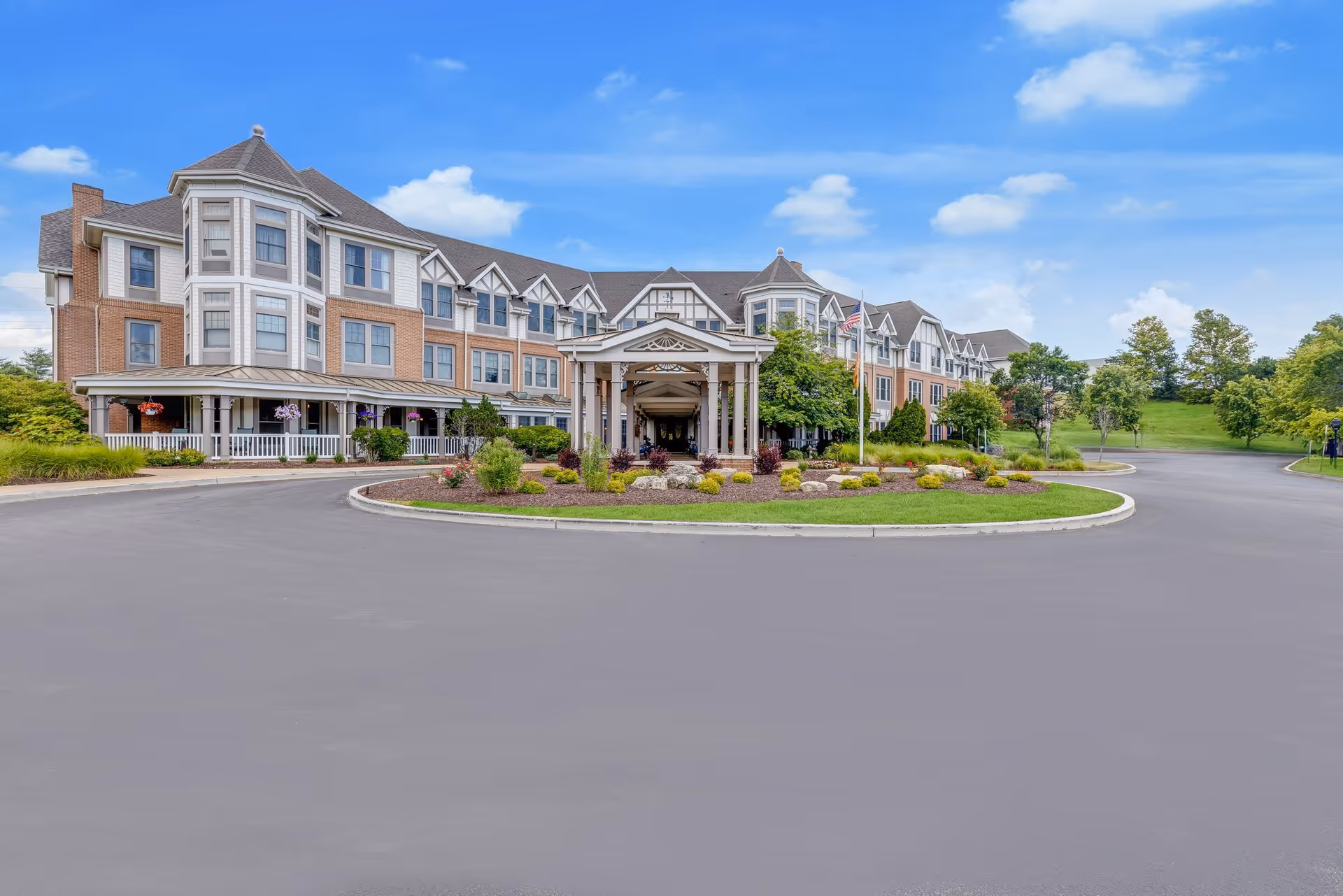Sunrise of Des Peres senior living facility with circular driveway and landscaped entrance.