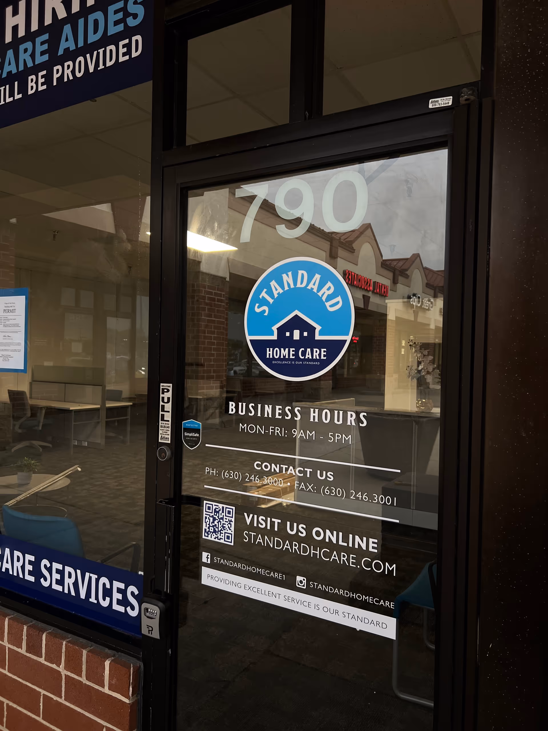 Glass storefront door with Standard Home Care logo, address 790, and business hours.