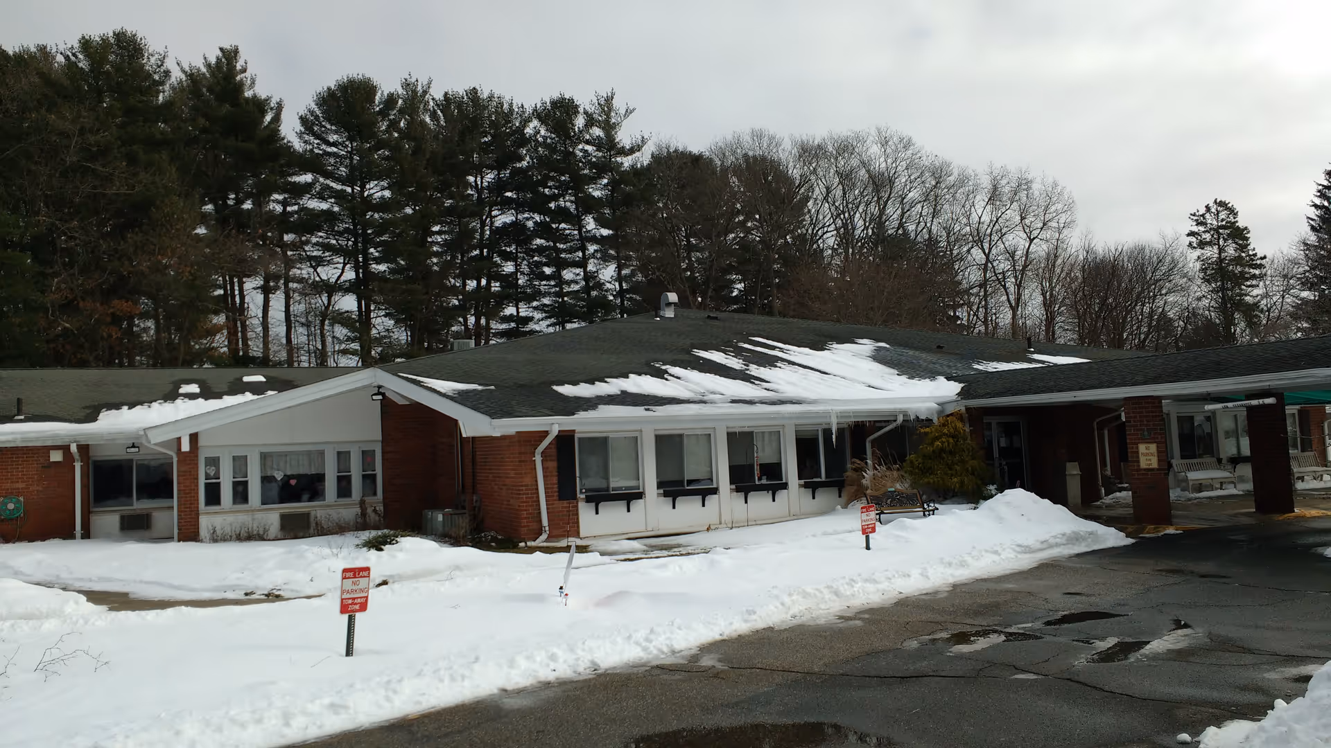 Front exterior of Complete Care at Fox Hill, a single-story brick building with snow.