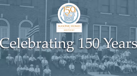 Front of Masonic Homes Kentucky building with a historic group photo and Celebrating 150 Years banner.
