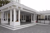 Covered entrance of The Lamp Memory Care Center with white columns and gray paving.
