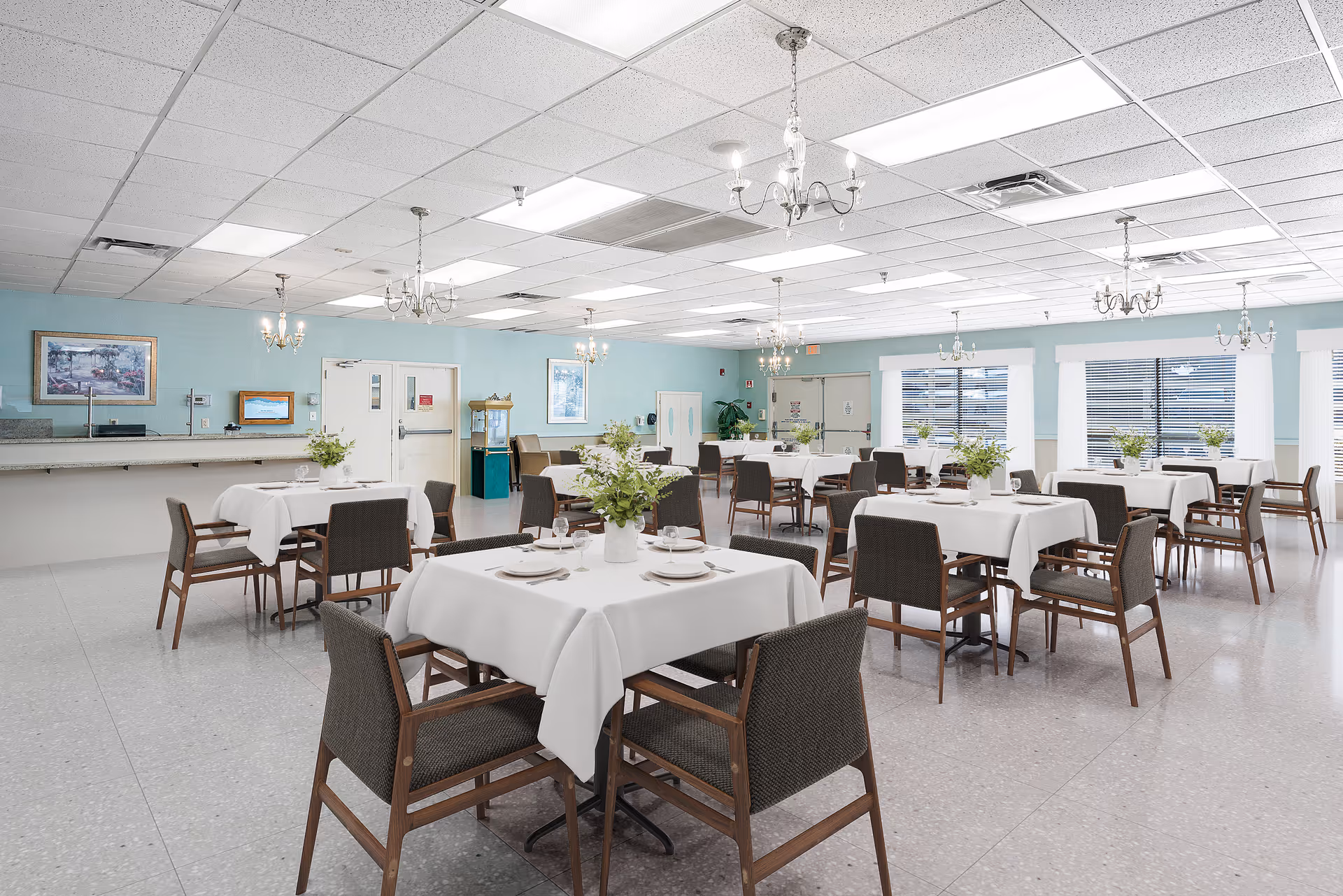 Spacious senior dining hall with round tables, white tablecloths, and potted centerpieces.