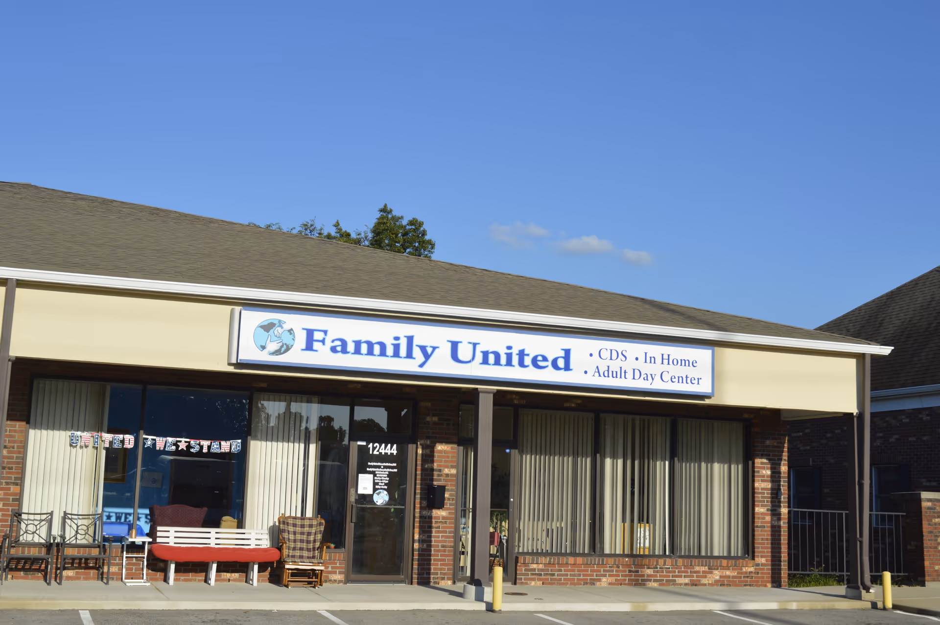 Front view of Family United storefront signage for an adult day center with outdoor seating.