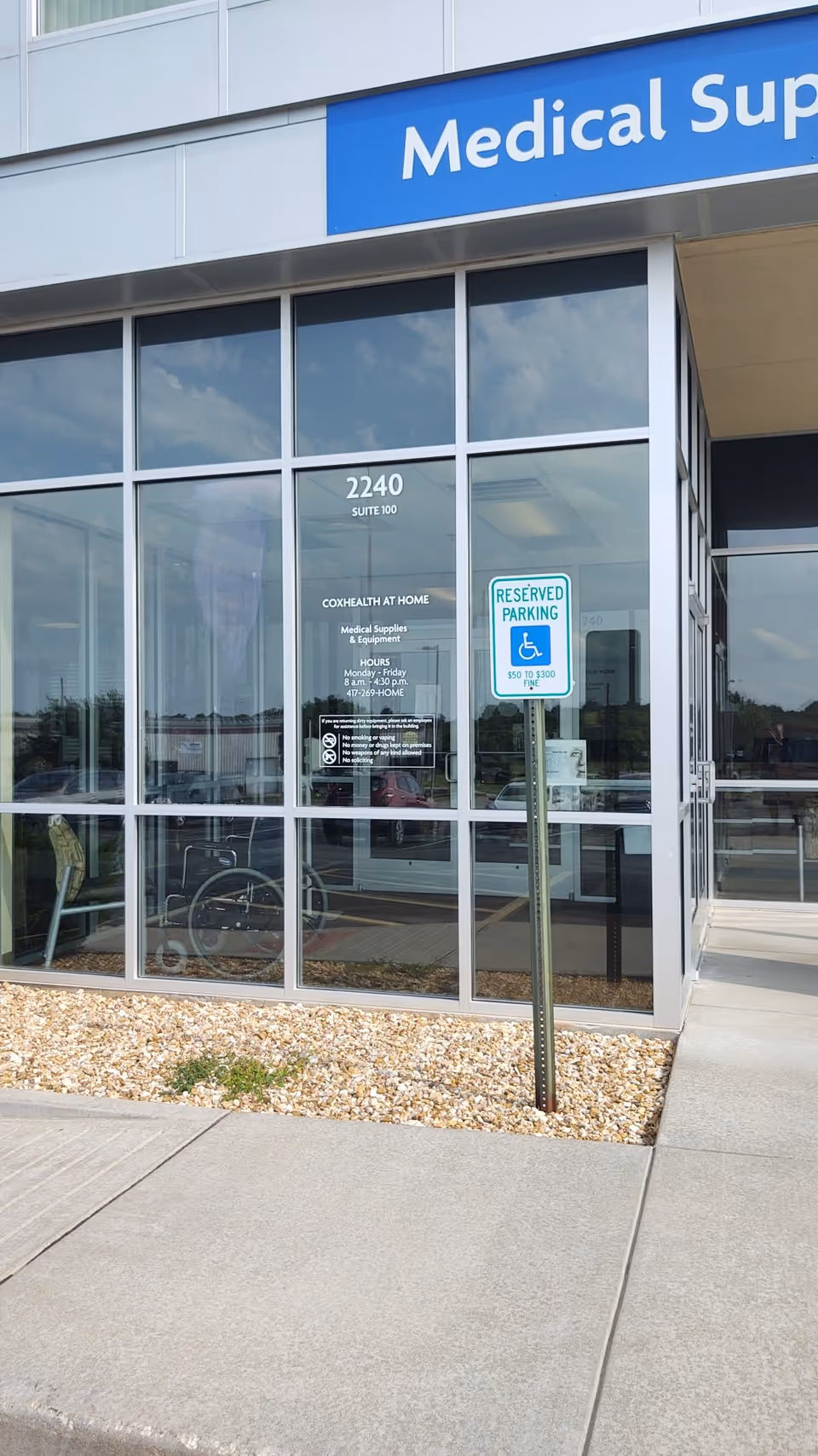 Exterior view of CoxHealth at Home storefront with large windows and a reserved parking sign.