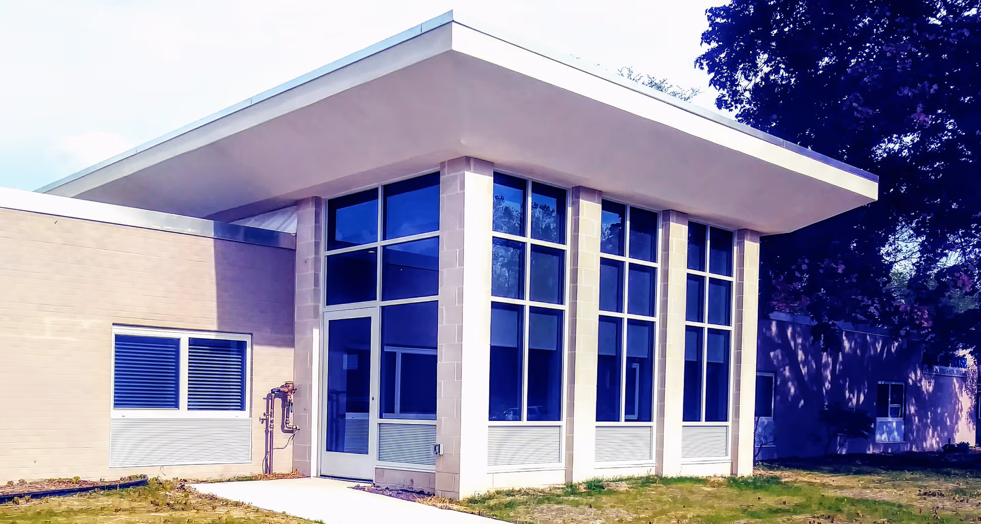 Modern glass-fronted senior living facility with large windows and a covered entrance.