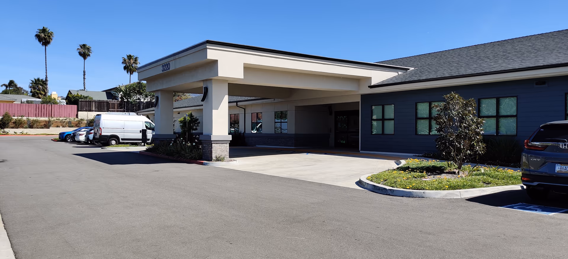 Exterior view of Pacific Villas Post Acute with entrance canopy and parking.
