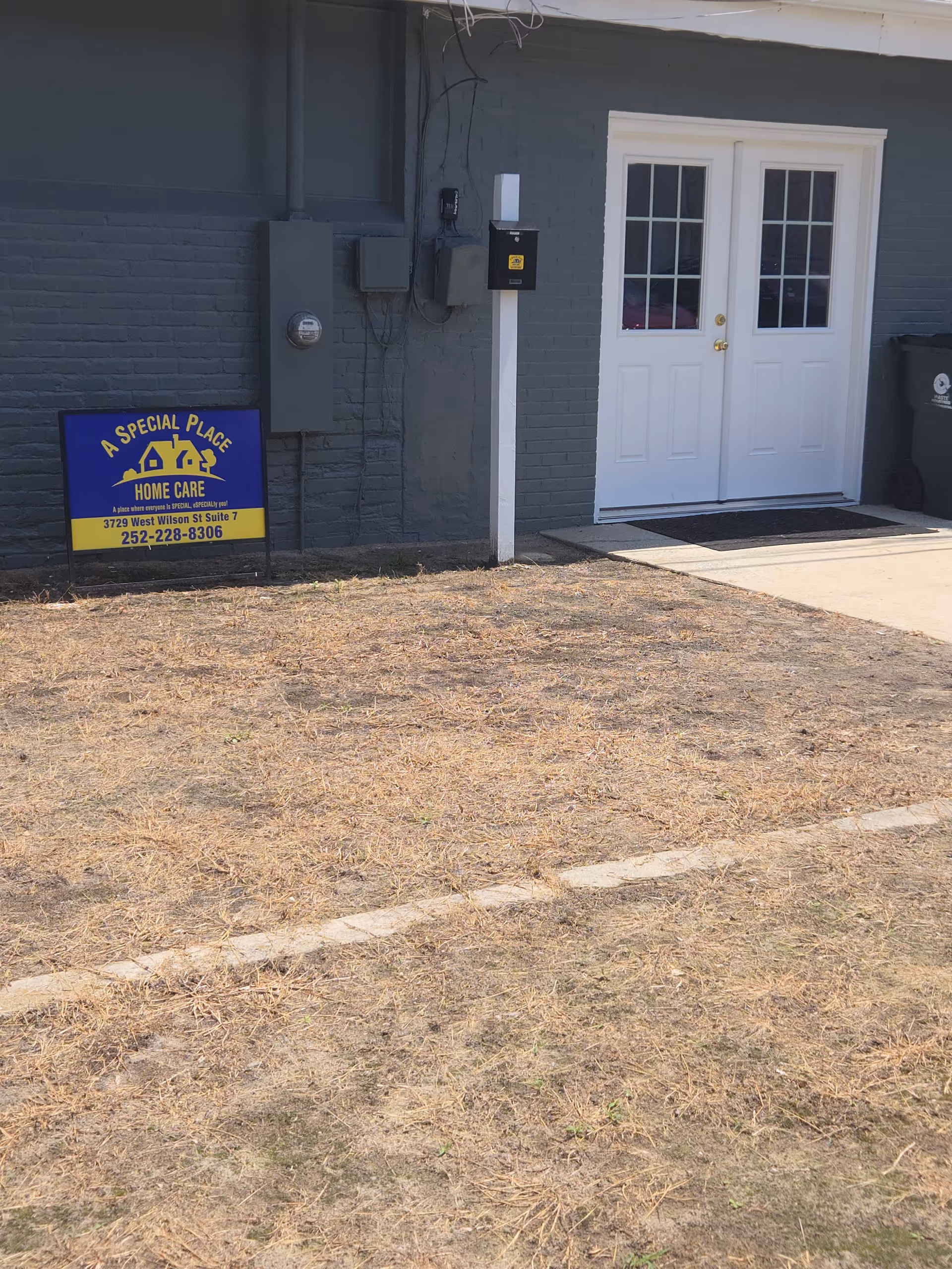 Exterior view of a facility entrance with a blue sign reading A Special Place Home Care