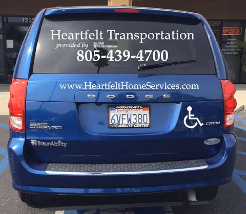 Blue van branded Heartfelt Transportation with wheelchair symbol parked in a lot.