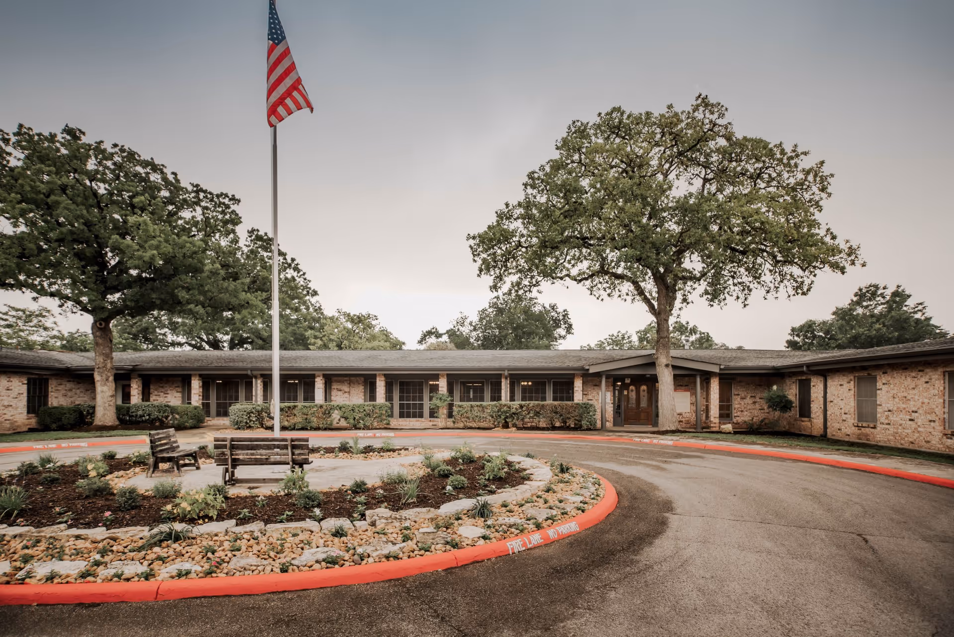 Exterior view of Santa Fe Health and Rehabilitation Center with brick building, flagpole, and landscaping.