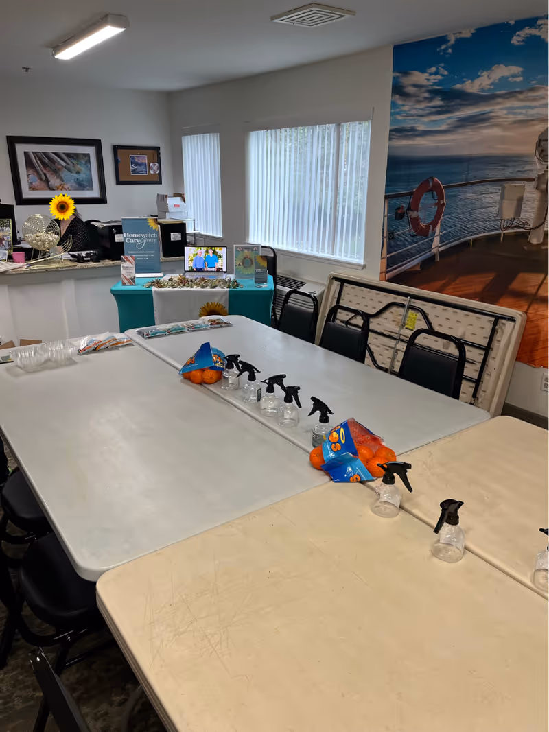 Activity room with long tables, spray bottles, snacks, and an ocean mural on the wall.