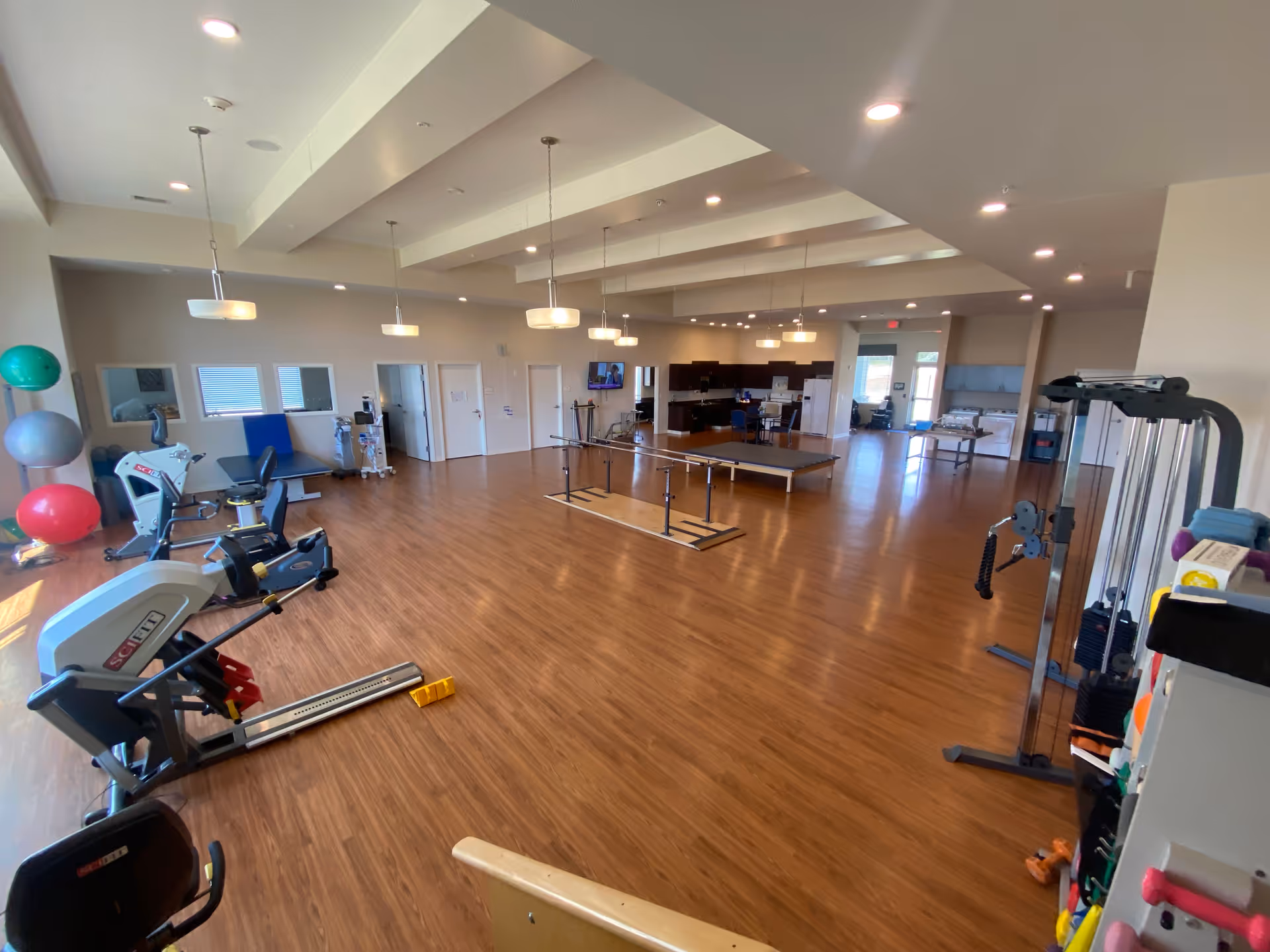 Interior view of Bluebonnet Point Wellness gym with cardio machines, balance equipment, and open space.