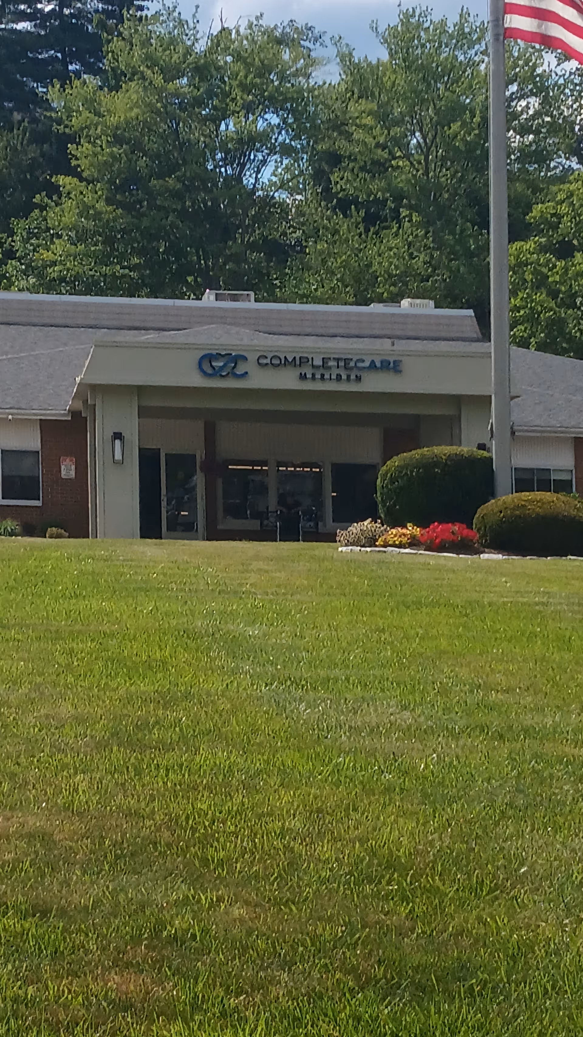 Exterior view of Complete Care at Meriden entrance with flag