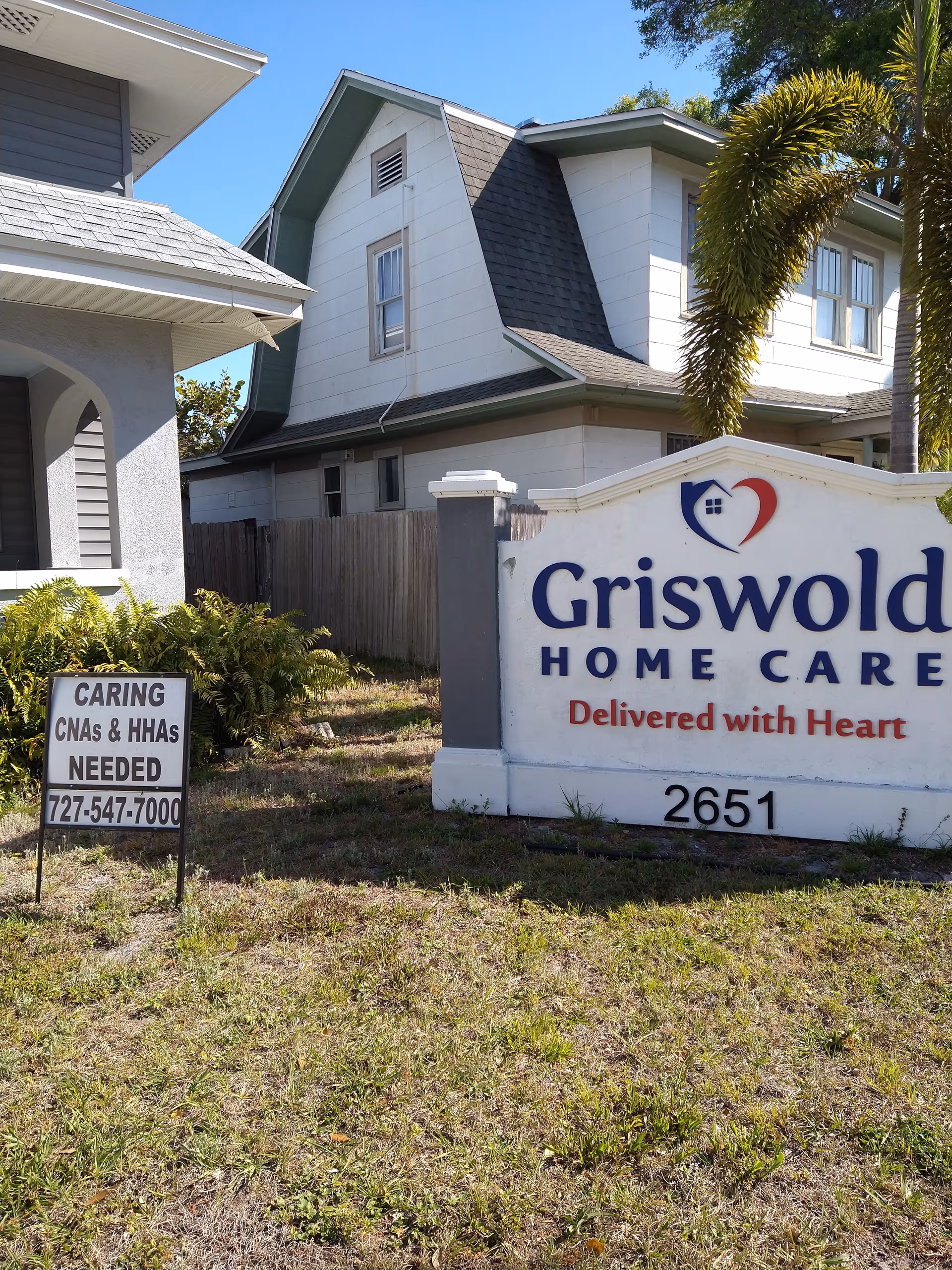 Exterior view of Griswold Home Care sign and two-story building on a sunny day.