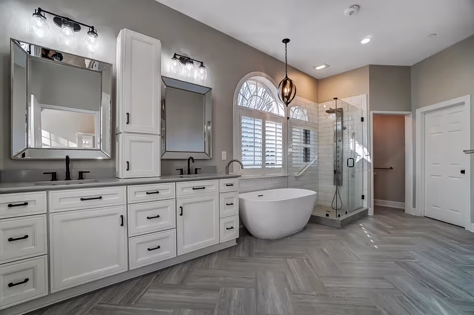 Spacious modern bathroom with double sinks, freestanding tub, and glass-enclosed shower.