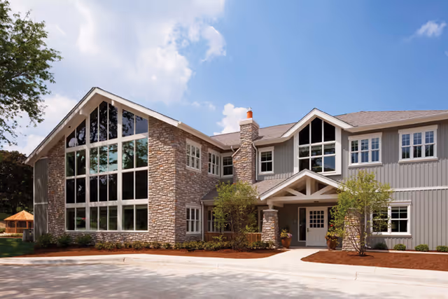 Exterior view of JourneyCare Hospice building with large windows and stone facade