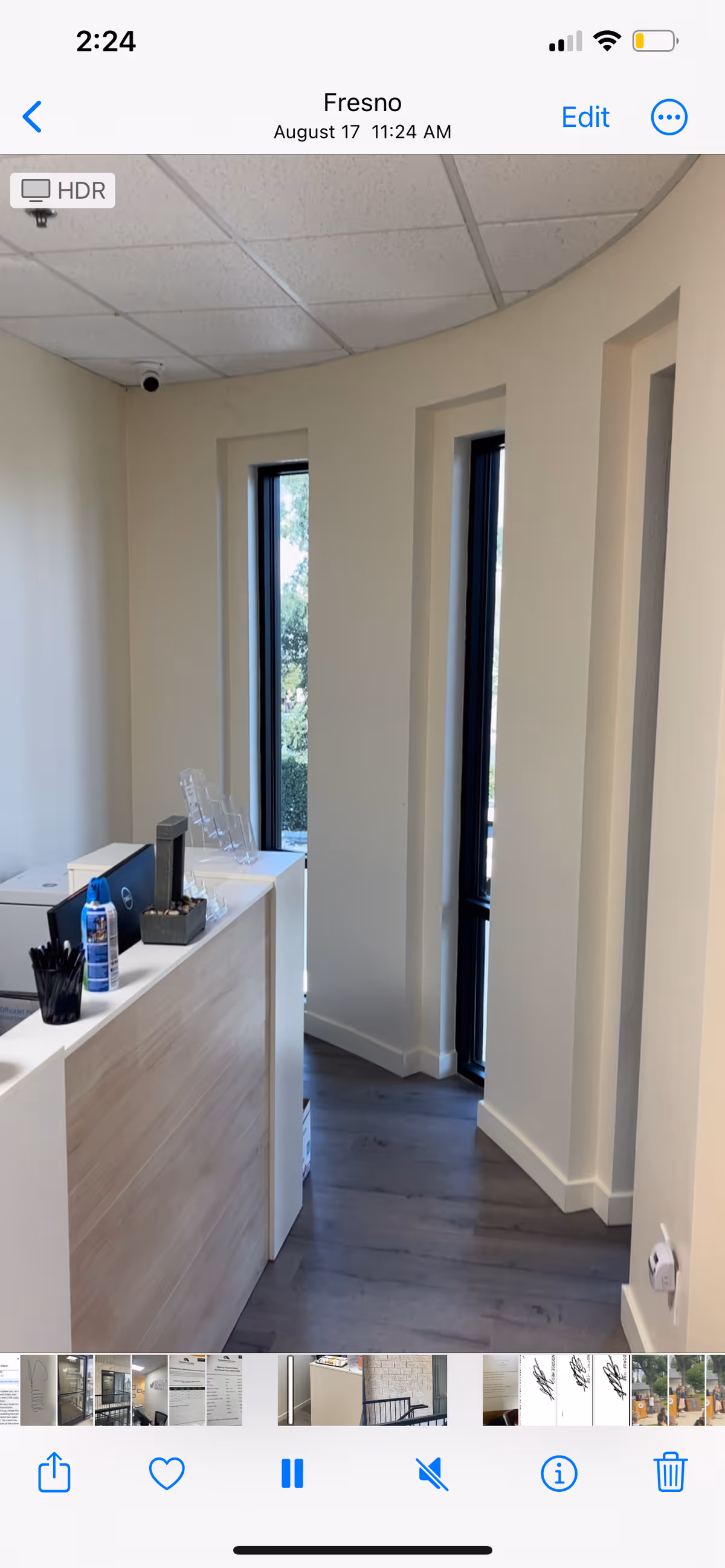 Reception counter inside a facility with tall vertical windows and light wood cabinetry.