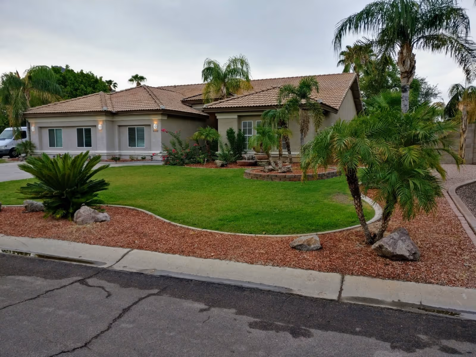 A single-story senior living facility with landscaped front yard and palm trees.