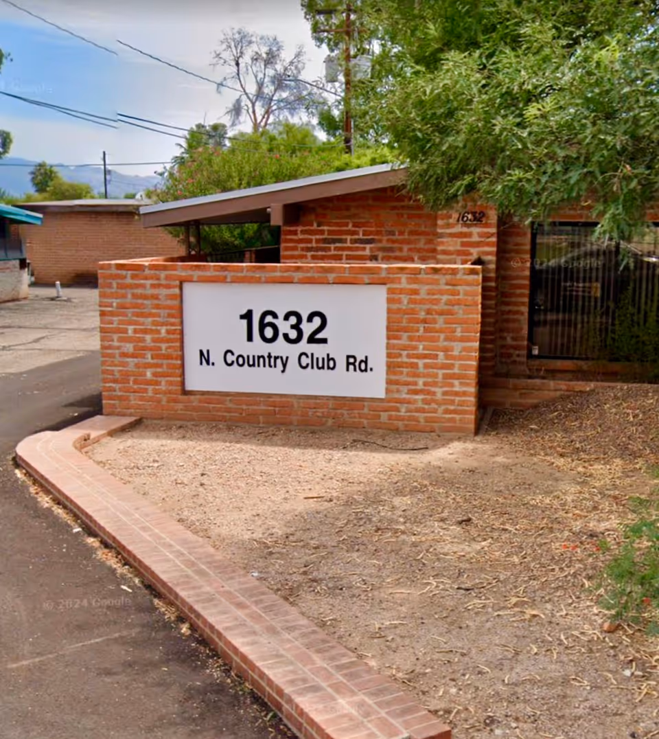 Brick entrance sign reading 1632 N. Country Club Rd in front of a low brick building.