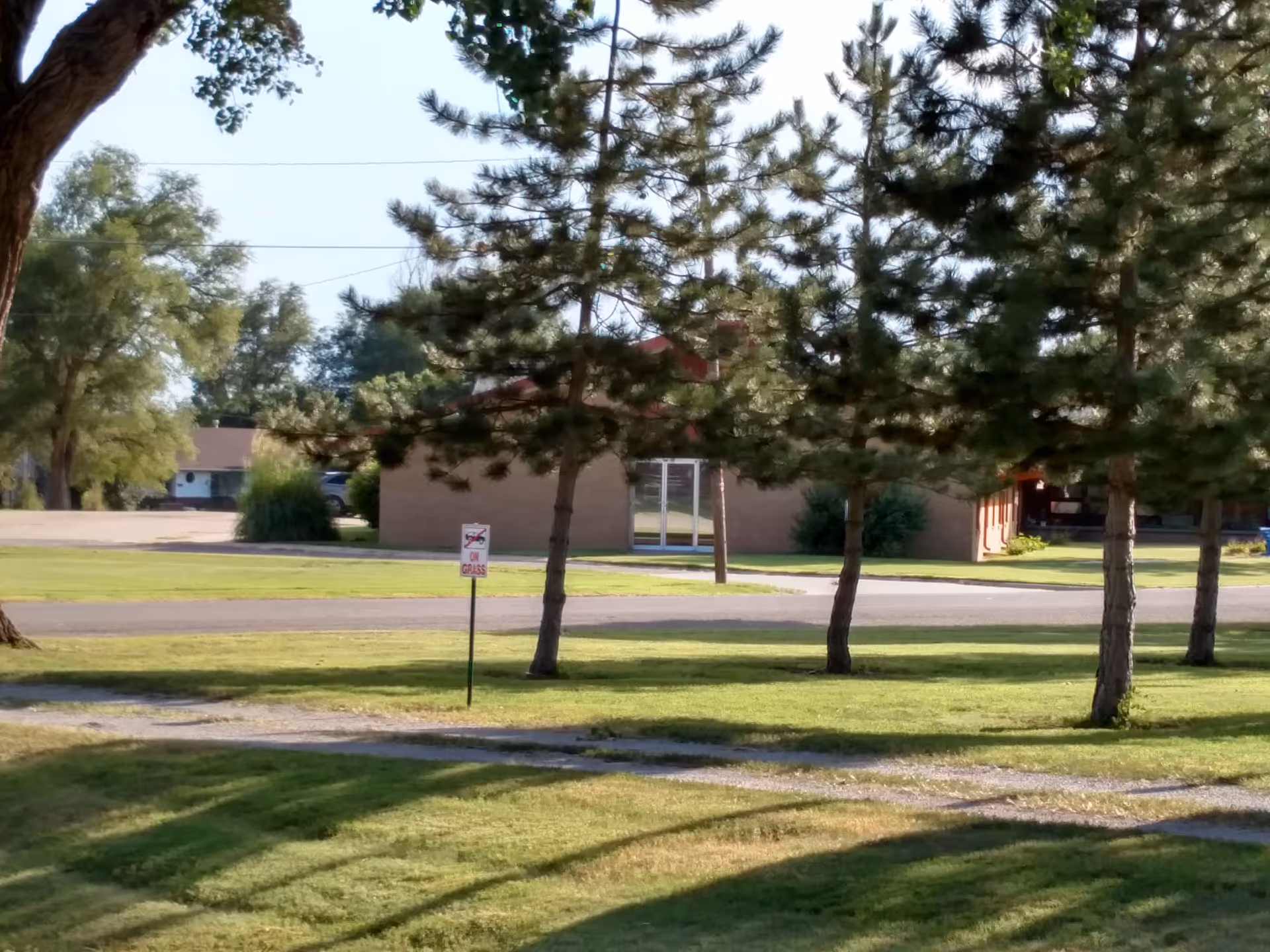 Exterior view of Pioneer Lodge with trees, lawn, and a path to the entrance.