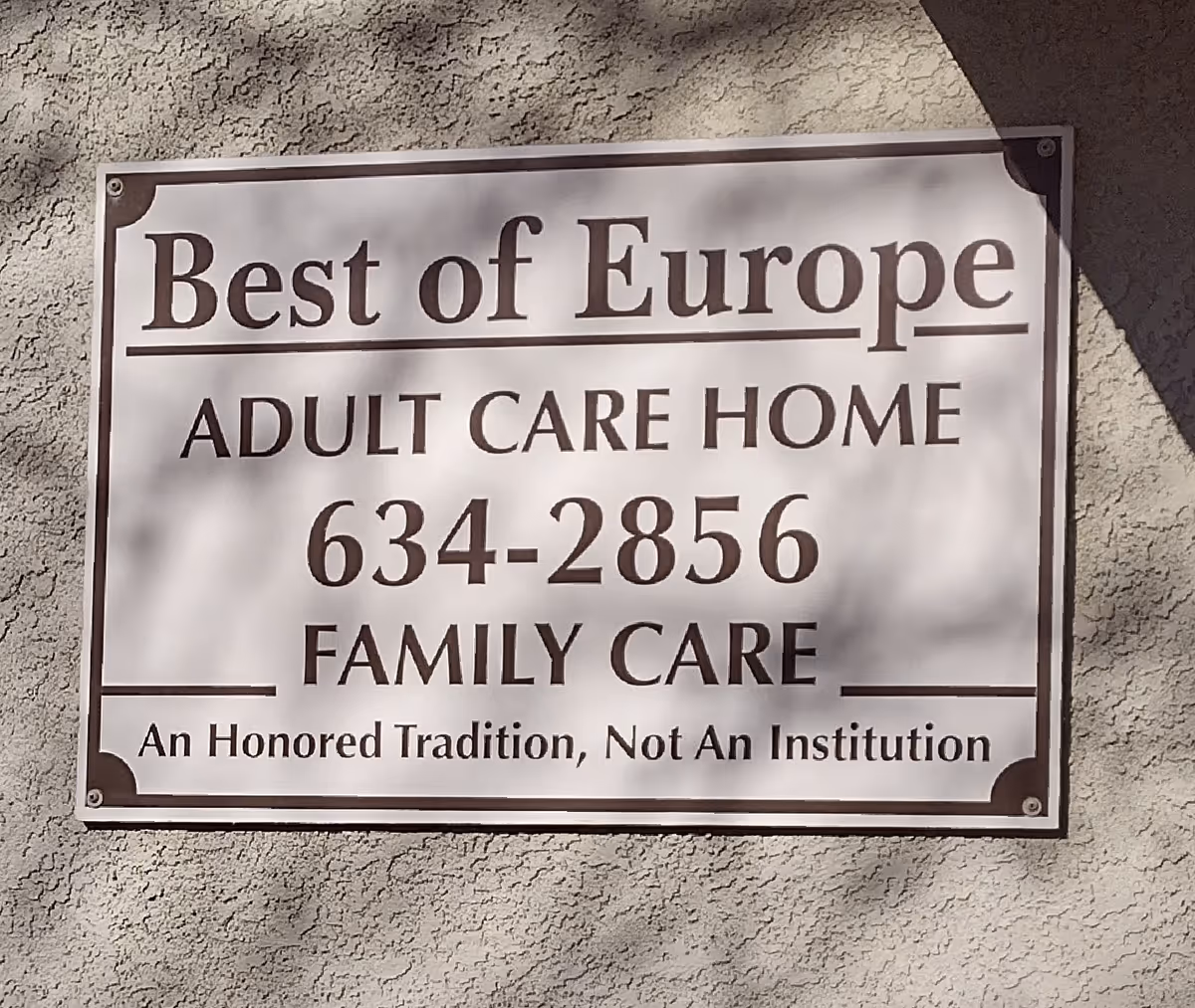 Exterior signage on stucco wall advertising Best of Europe Adult Care Home.
