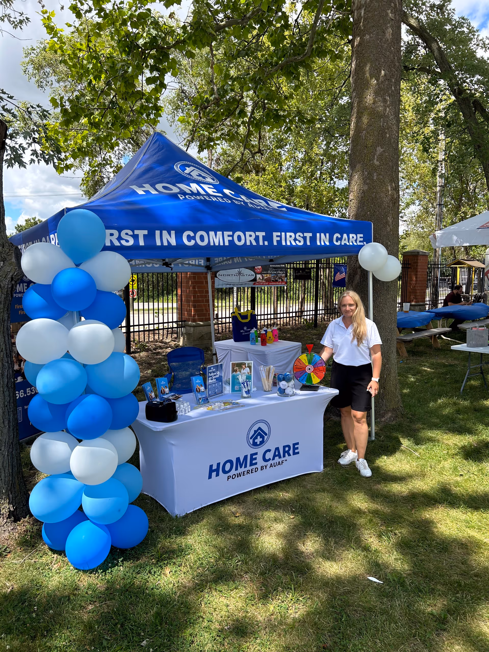 Outdoor promotional booth for Home Care powered by AUAF with balloons and a wheel of fortune