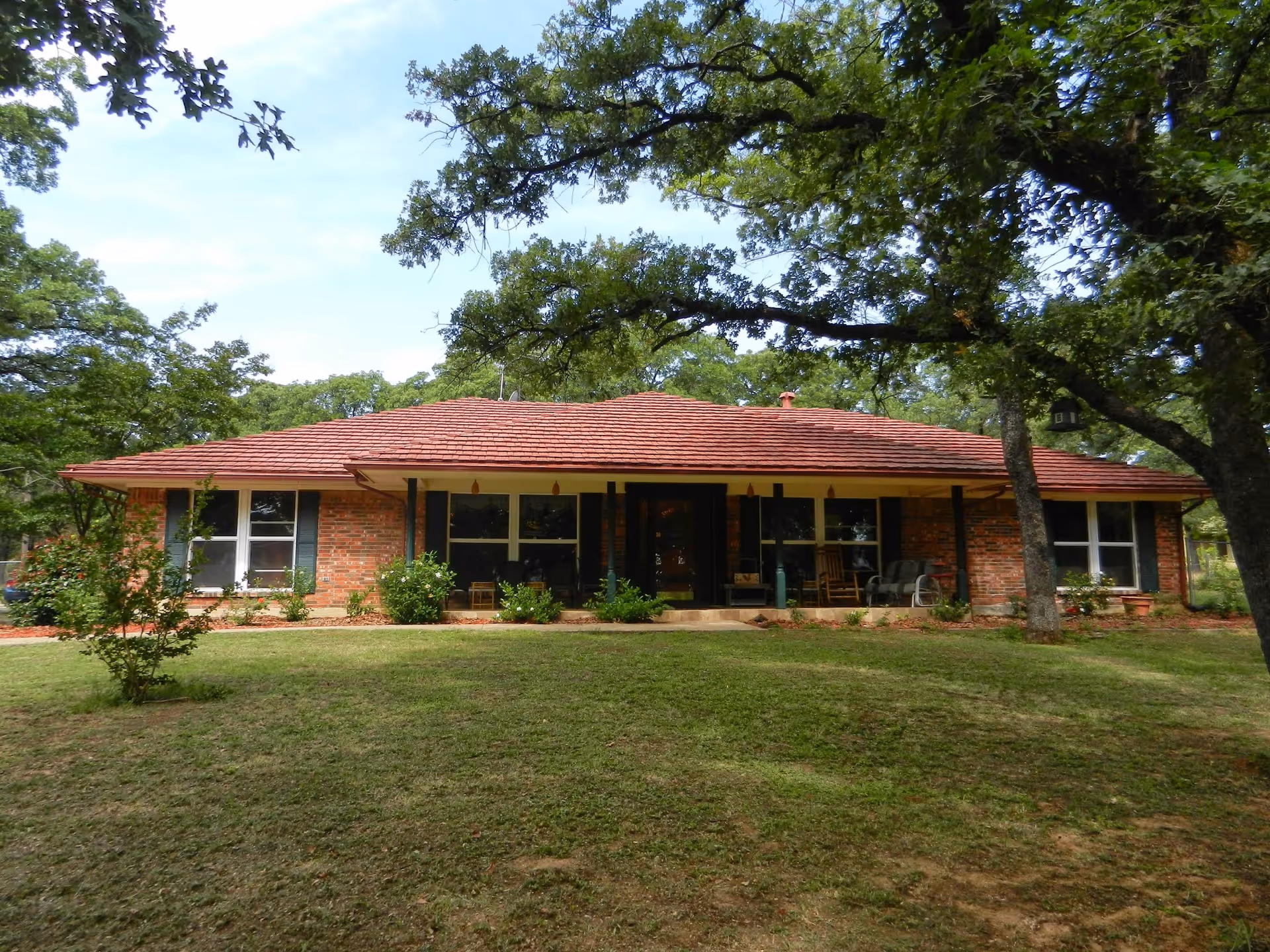 Single-story brick senior living facility with a covered front porch and lawn.