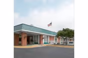 Front exterior of Charlottesville Health and Rehabilitation Center with entrance canopy and flag