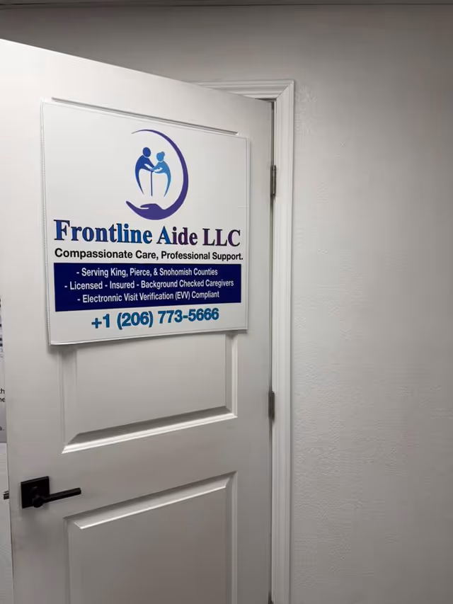 White interior door with Frontline Aide LLC sign inside a senior living facility.