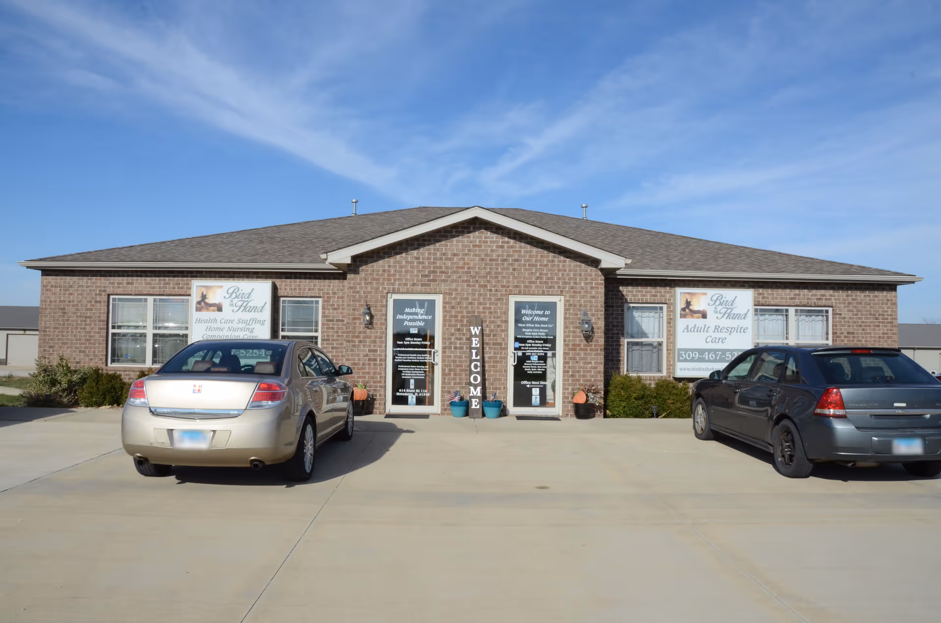 Brick senior living facility storefront with signage and parked cars in front.