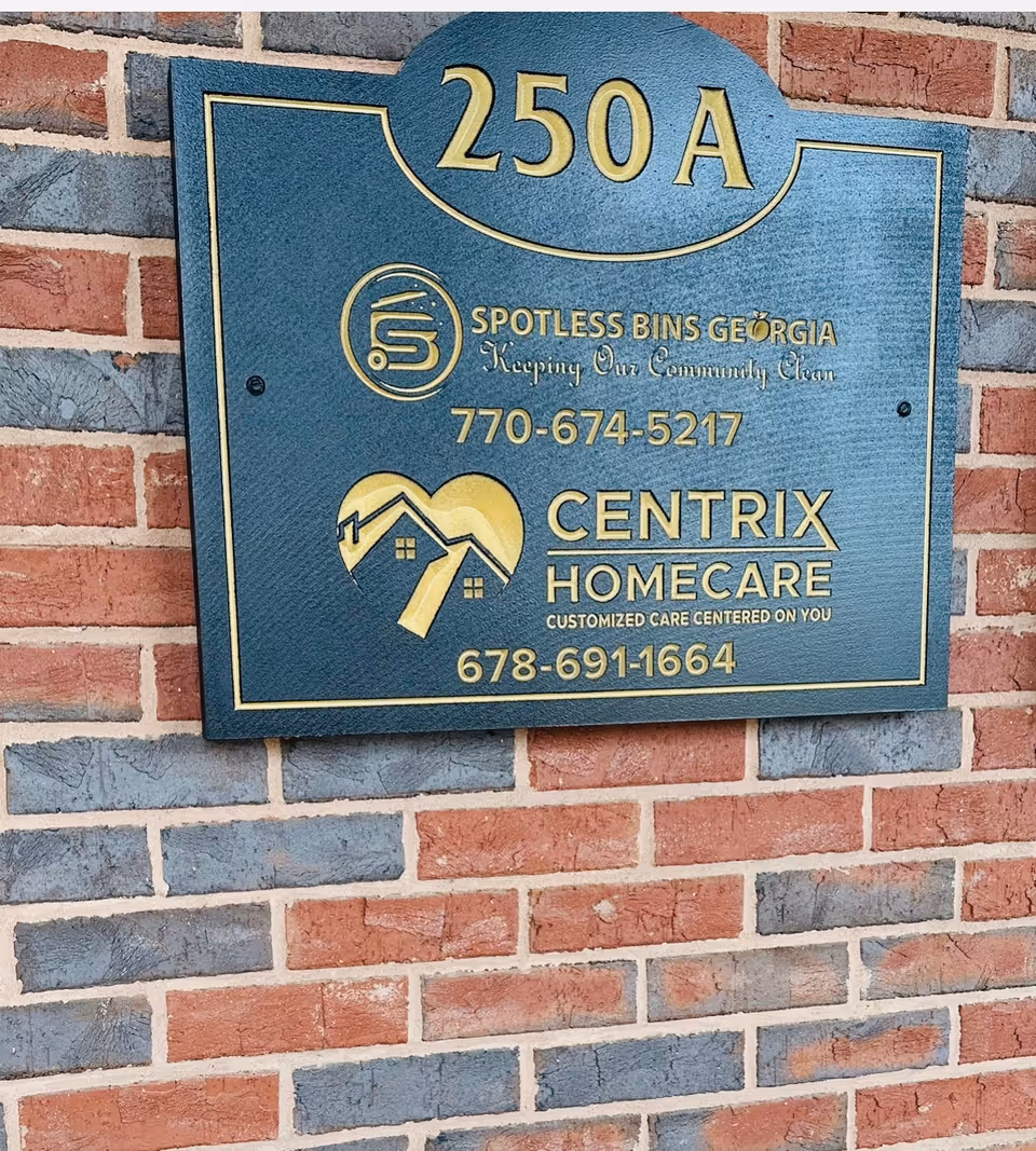 Blue sign plaque mounted on a brick wall with Centrix Homecare details.
