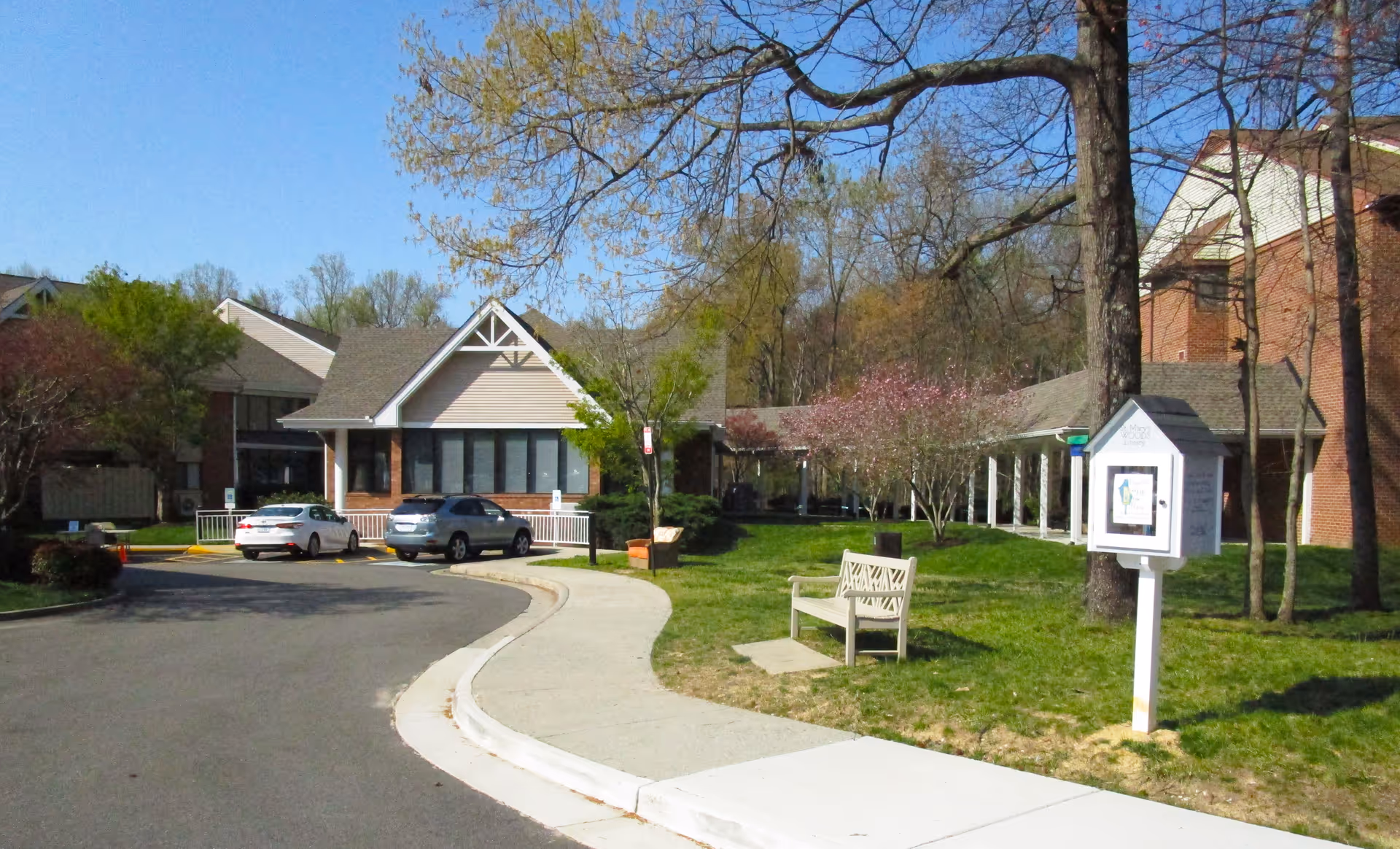 Exterior view of St. Mary's Woods senior living facility with driveway and parked cars.