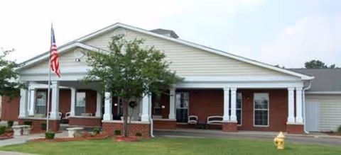 Front exterior of Brookdale Cleveland showing a brick façade, porch with columns, flag, and lawn.