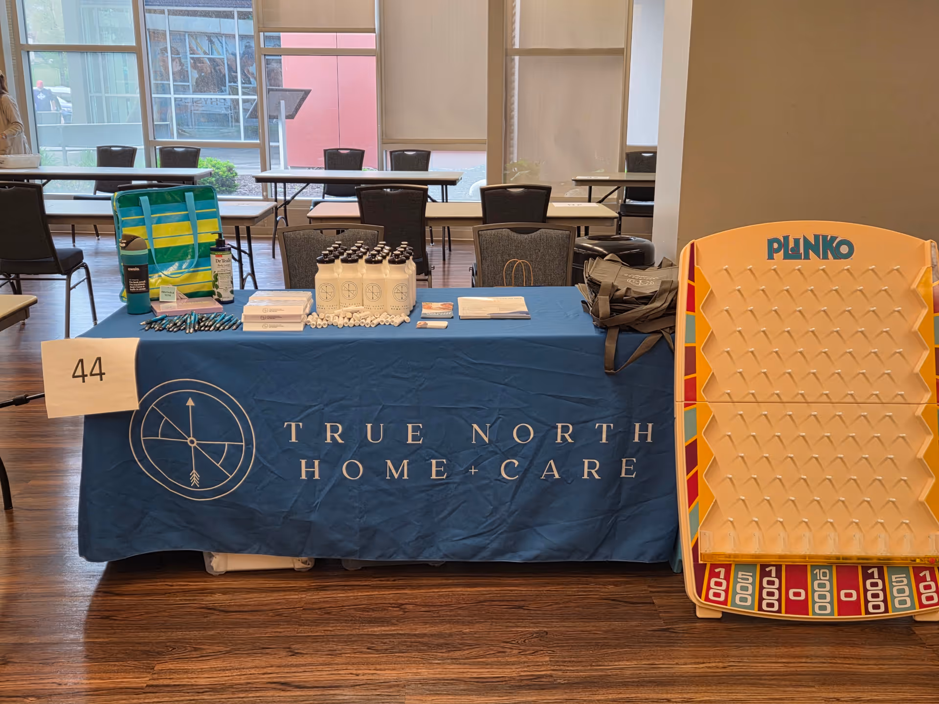 Promotional information table for True North Home Care with a Plinko board in an open room.