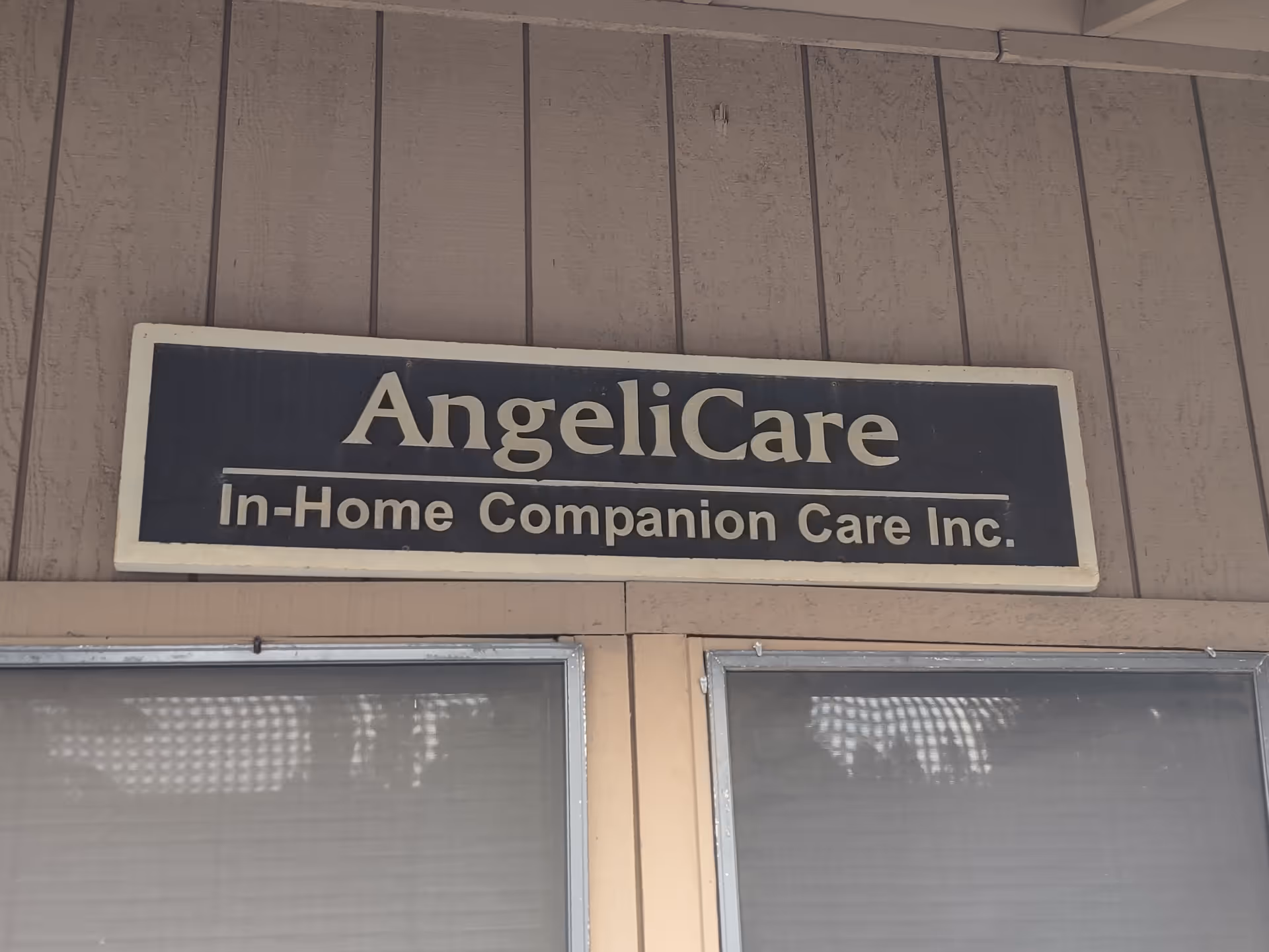 Exterior view of Angelicare In-Home Companion Care sign on the building front