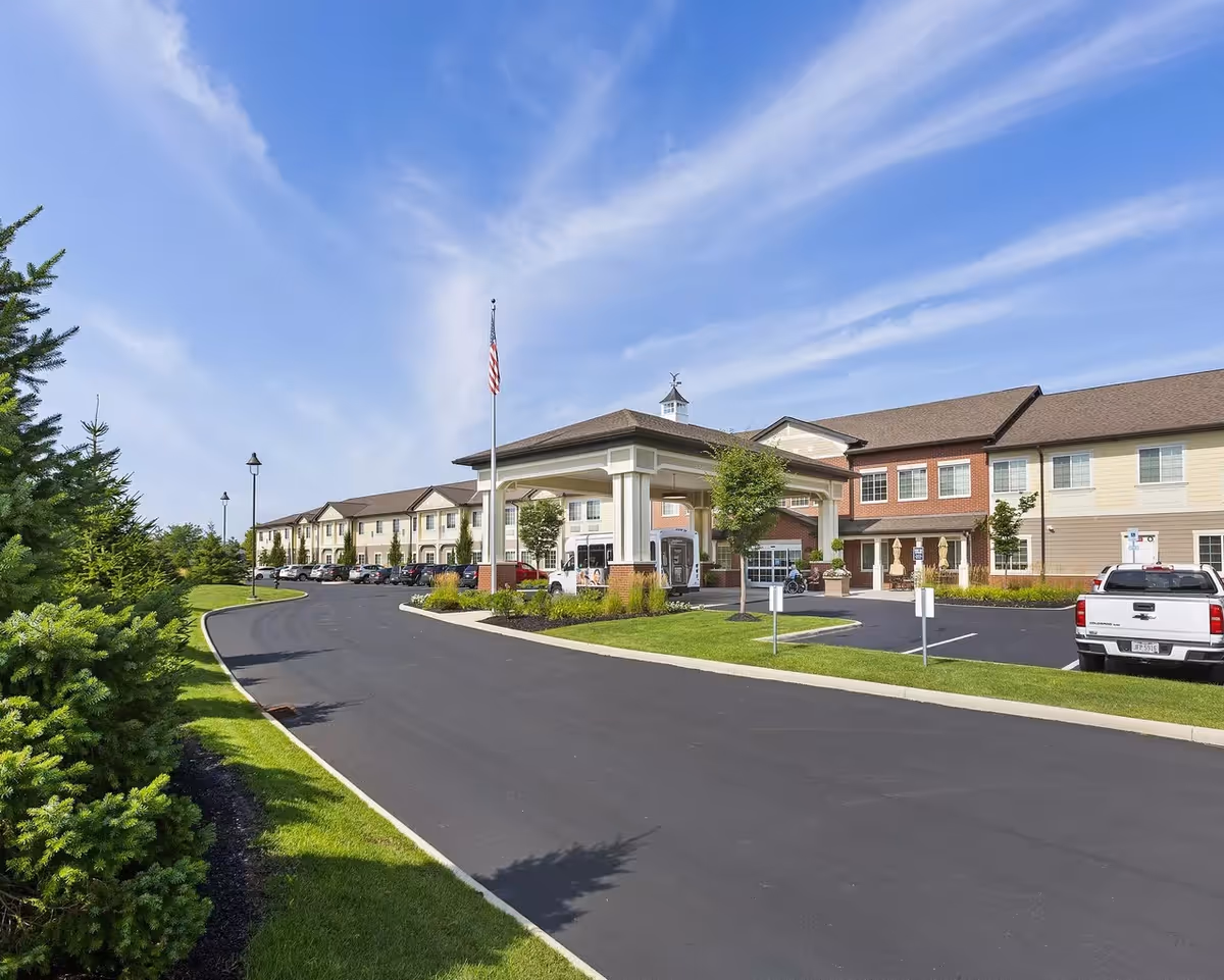 Wide view of StoryPoint Powell senior living facility exterior with entrance canopy and parking.