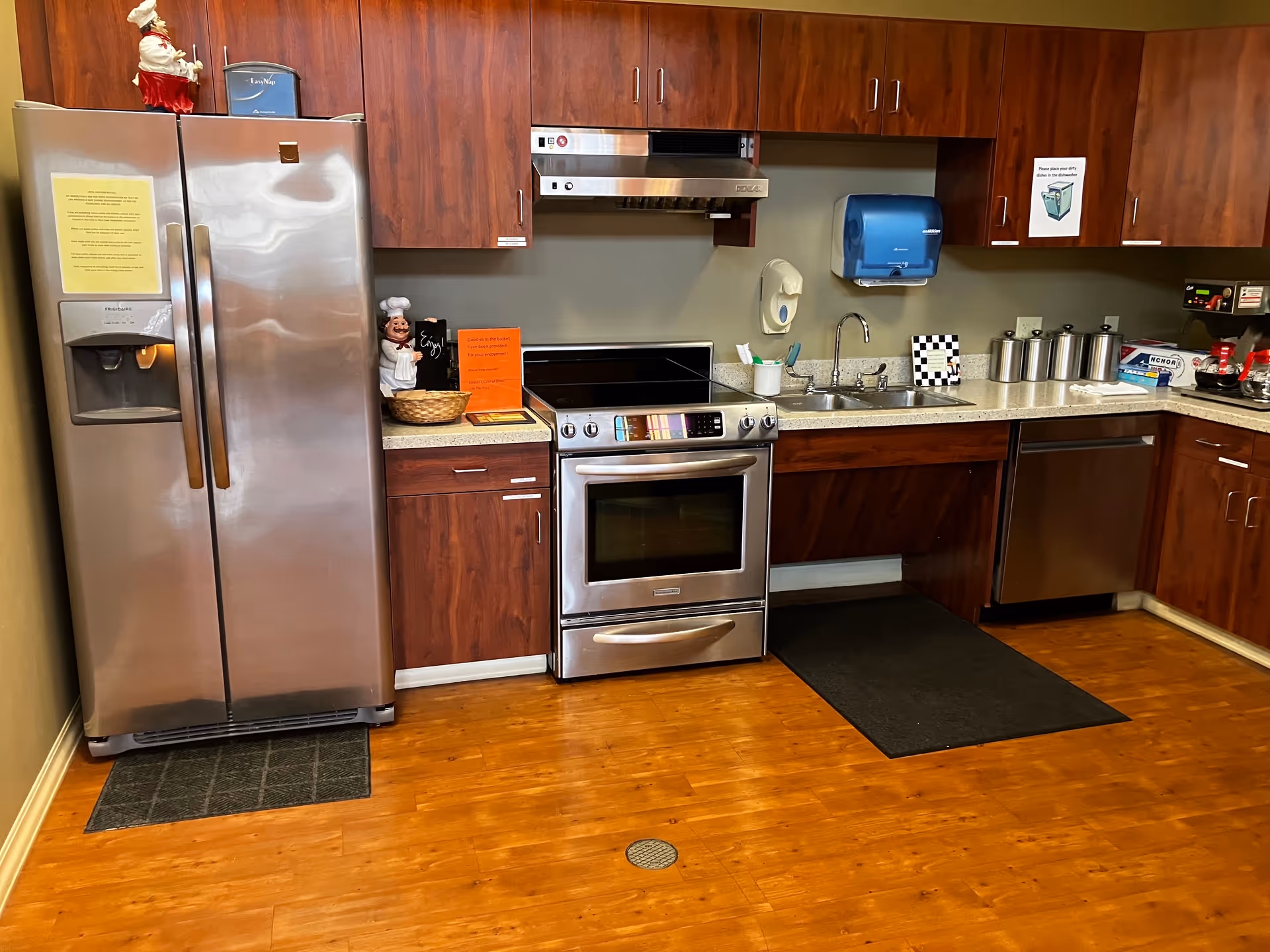 Stainless steel appliances and wooden cabinets fill a compact kitchen in the facility.