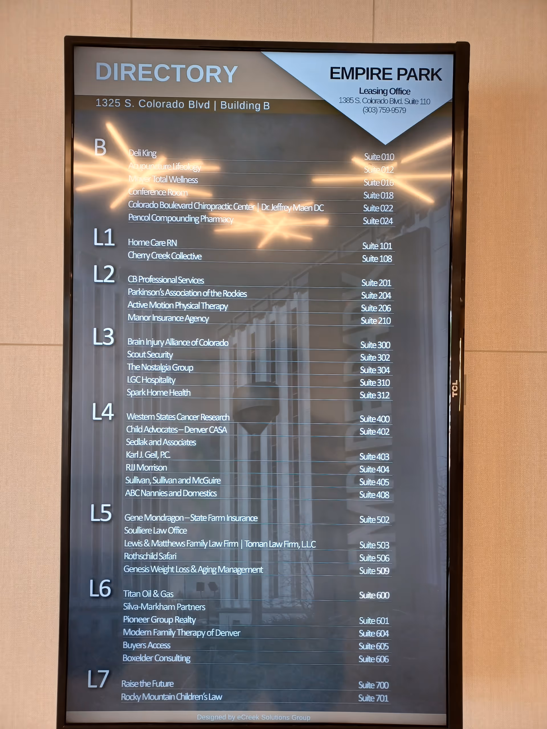 Tall electronic directory sign listing tenants and floor numbers inside a building.