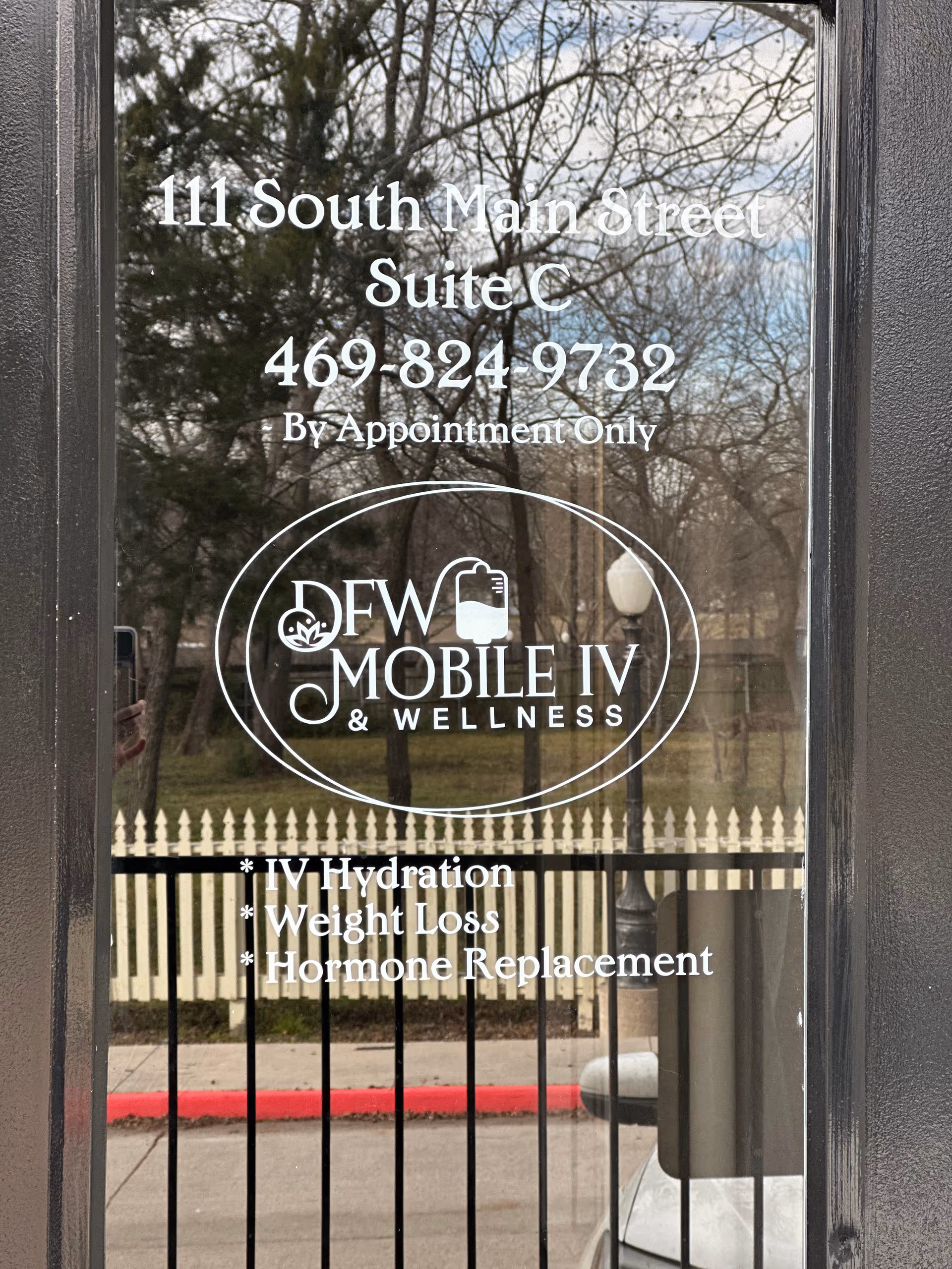 Glass entry door displays DFW Mobile IV & Wellness branding with address and services.